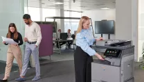 A woman using an MFP in an office