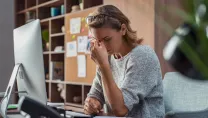 Business woman with headache in office