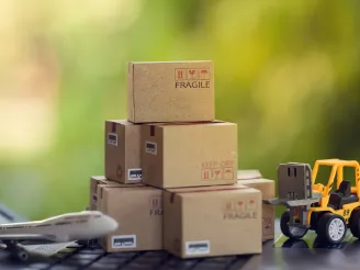 A stack of boxes next to a plane and a truck