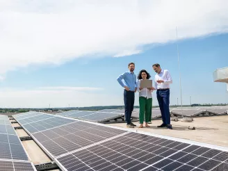 commercial rooftop solar energy installation three business people