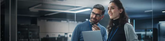 Two engineers with a laptop in a control room